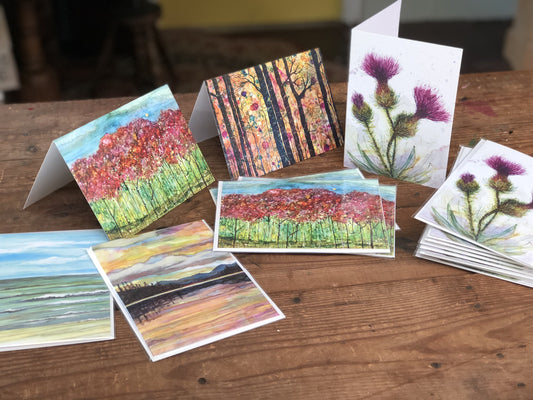 Collection of artistic greeting cards on a wooden surface