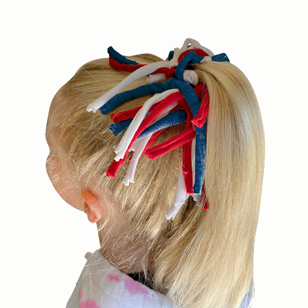 Child's hair with red, white, and blue hair accessories.
