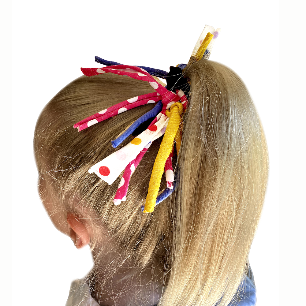 Colorful hair accessories in a child's hair on a white background