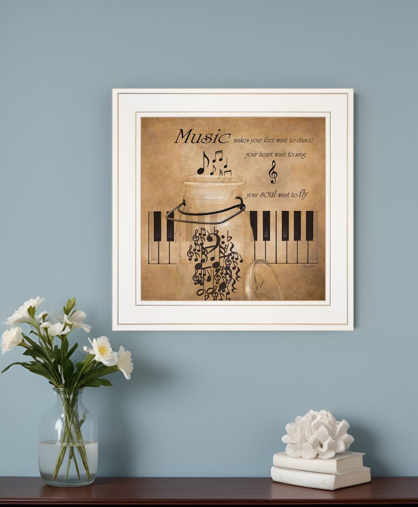 Framed music-themed artwork on a wall with a vase and decorative items below.
