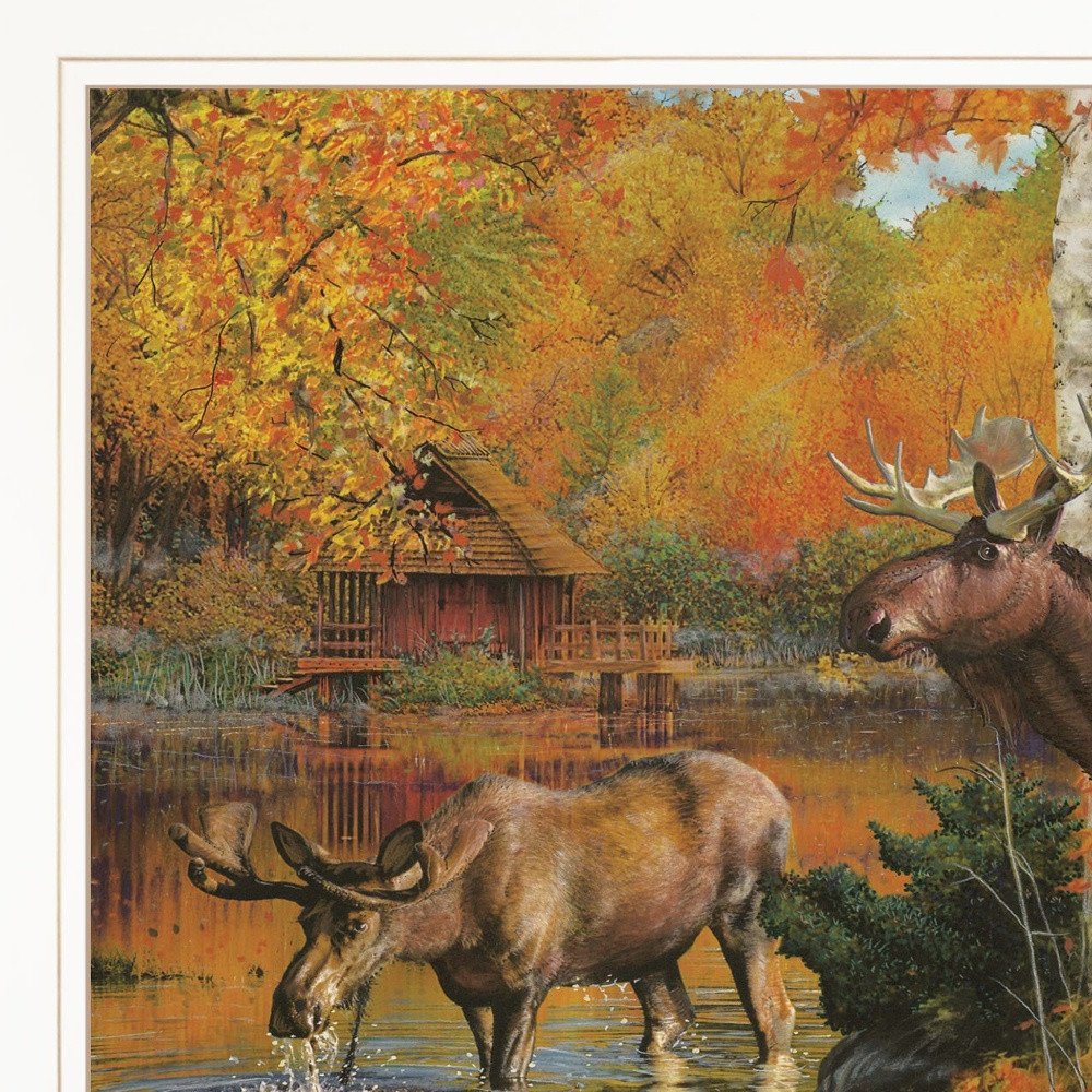 Two moose by a lake with a wooden cabin in the background during autumn.