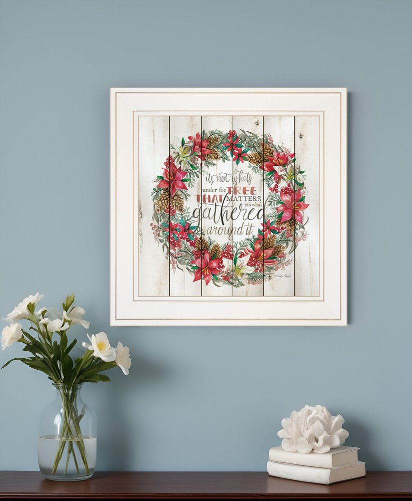 Framed artwork with floral design and text on a blue wall with decorative items below.