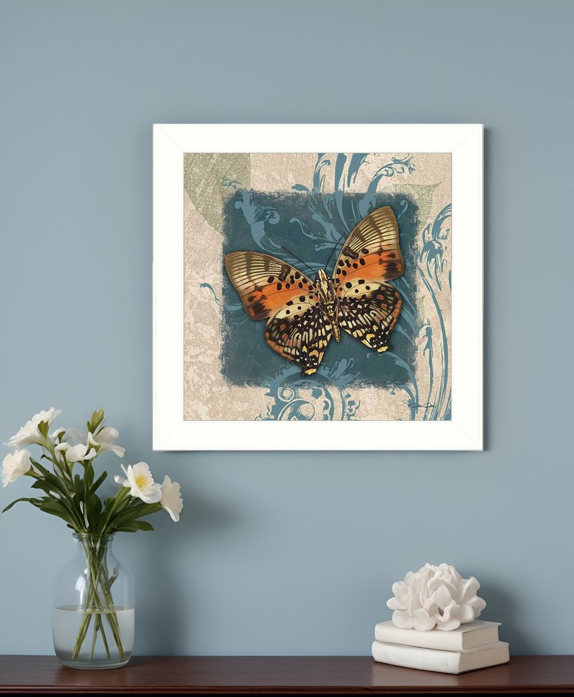Framed butterfly artwork on a wall with a vase of flowers and decorative items below.