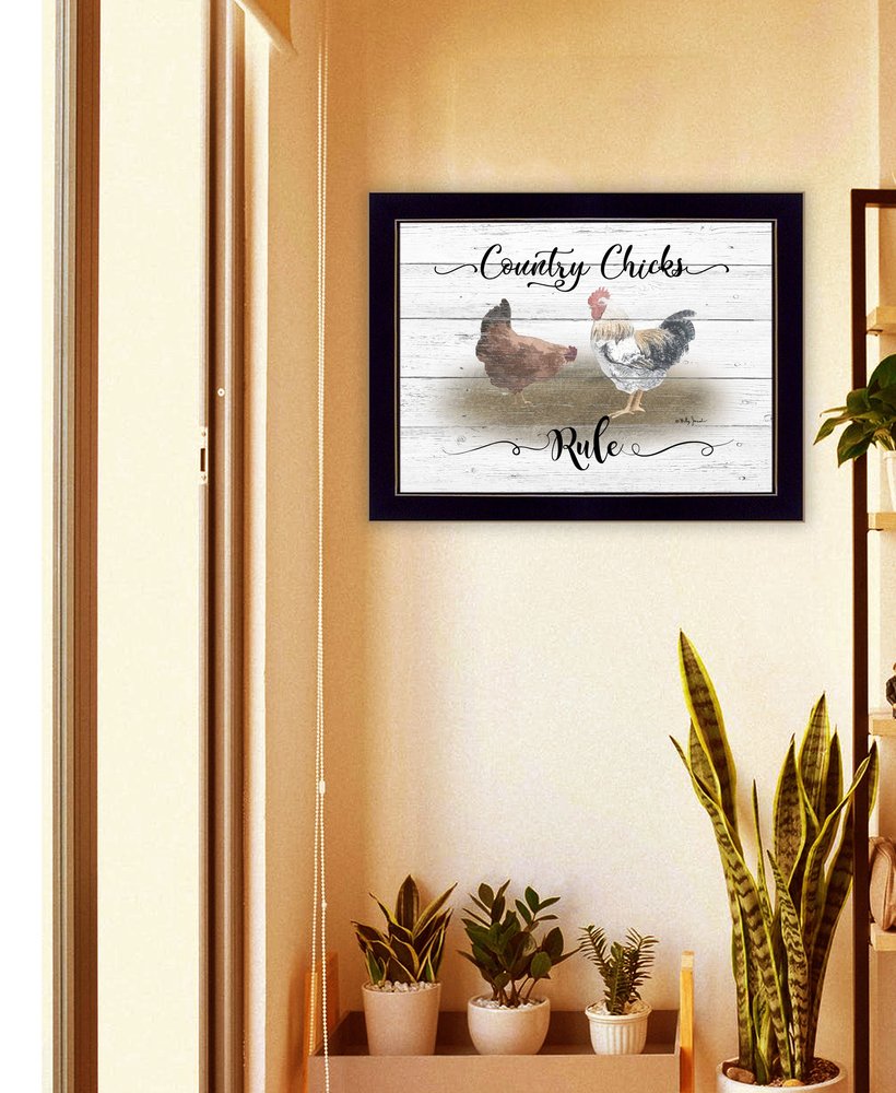 Framed artwork with chickens and text on a wall above a shelf with plants.