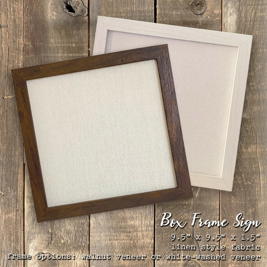 Two box frame signs on a wooden surface with text describing the product.