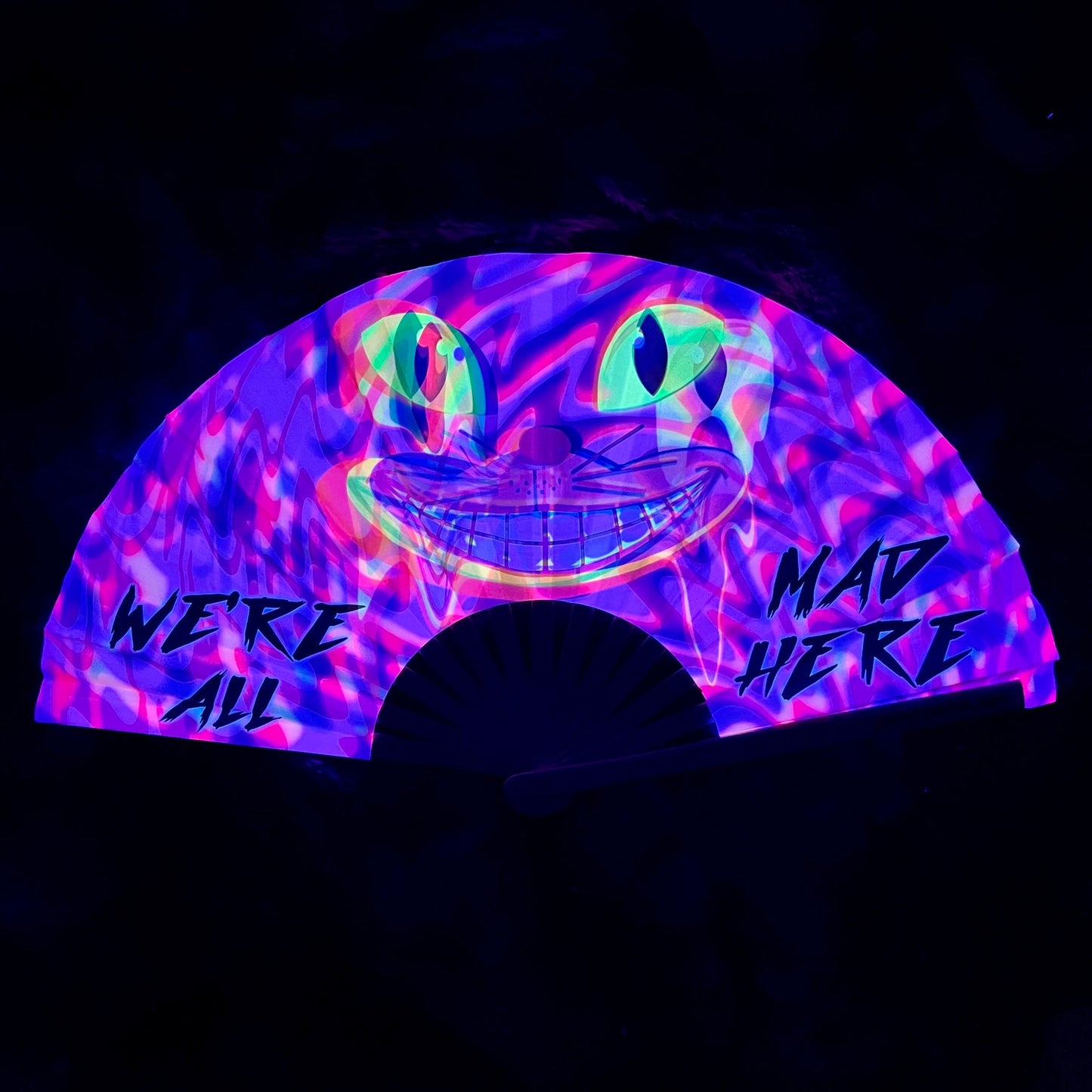 Glowing fan with colorful design and text 'We're all mad here' on a dark background