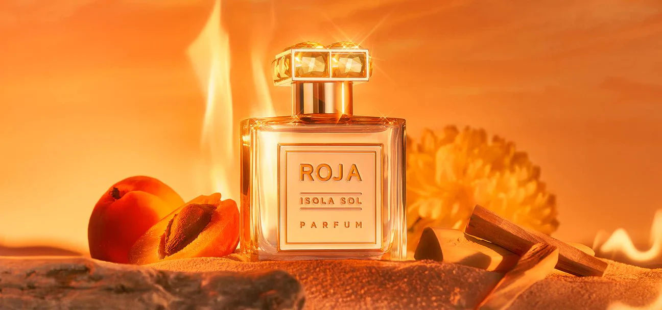 Roja Isola Sol parfum bottle with peaches on a warm-toned background