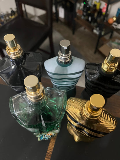 Collection of perfume bottles on a dark surface with a blurred background