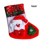 A set of Christmas stockings with festive designs including Santa Claus, reindeer, and snowflakes, displayed on a white mantelpiece.