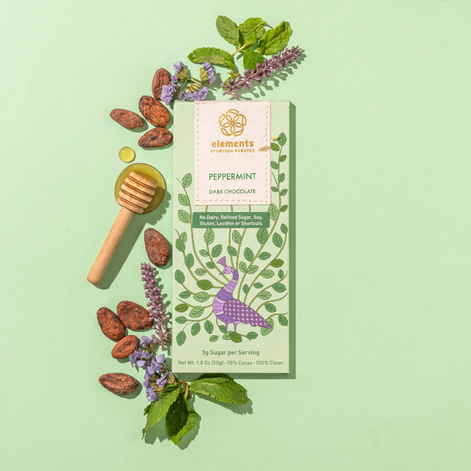 Dark chocolate bar with peppermint flavor packaging on a green background with herbs and honeycomb.