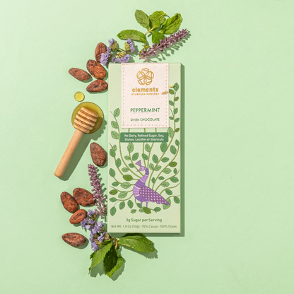 Dark chocolate bar with peppermint flavor packaging on a green background with herbs and honeycomb.