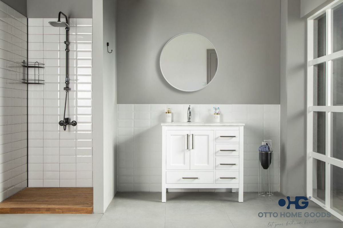 Bathroom with white vanity, round mirror, and shower area.