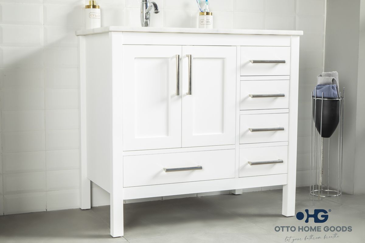 White bathroom vanity with sink and drawers in a bathroom setting.