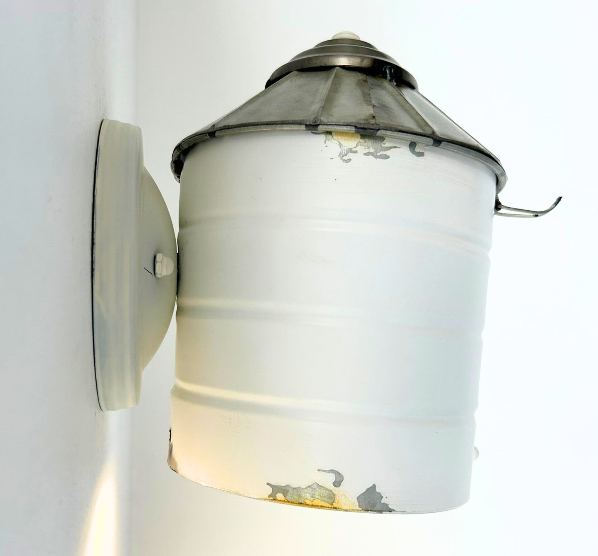 Wall-mounted light fixture with glass shade on a white background