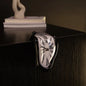 Heart-shaped clock on a dark surface with a blurred background
