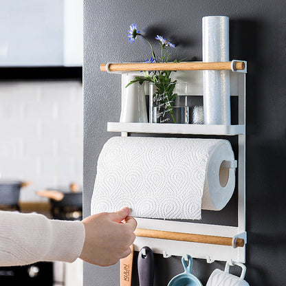 Wall-mounted kitchen organizer with paper towels, cups, and a plant.