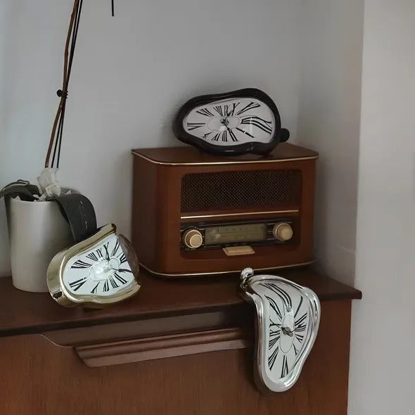 Vintage-style radio with three unique clock designs on a wooden surface.