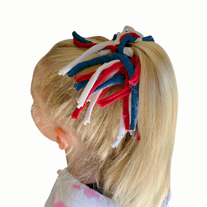 Child's hair with red, white, and blue hair accessories.
