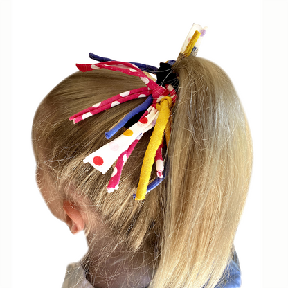 Colorful hair accessories in a child's hair on a white background