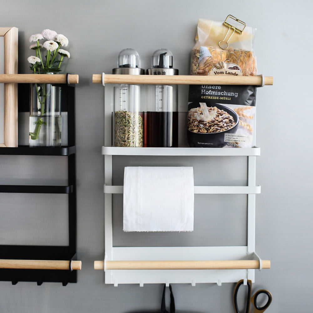 Wall-mounted shelf with various items including a towel, bottles, and a bag on a gray wall.