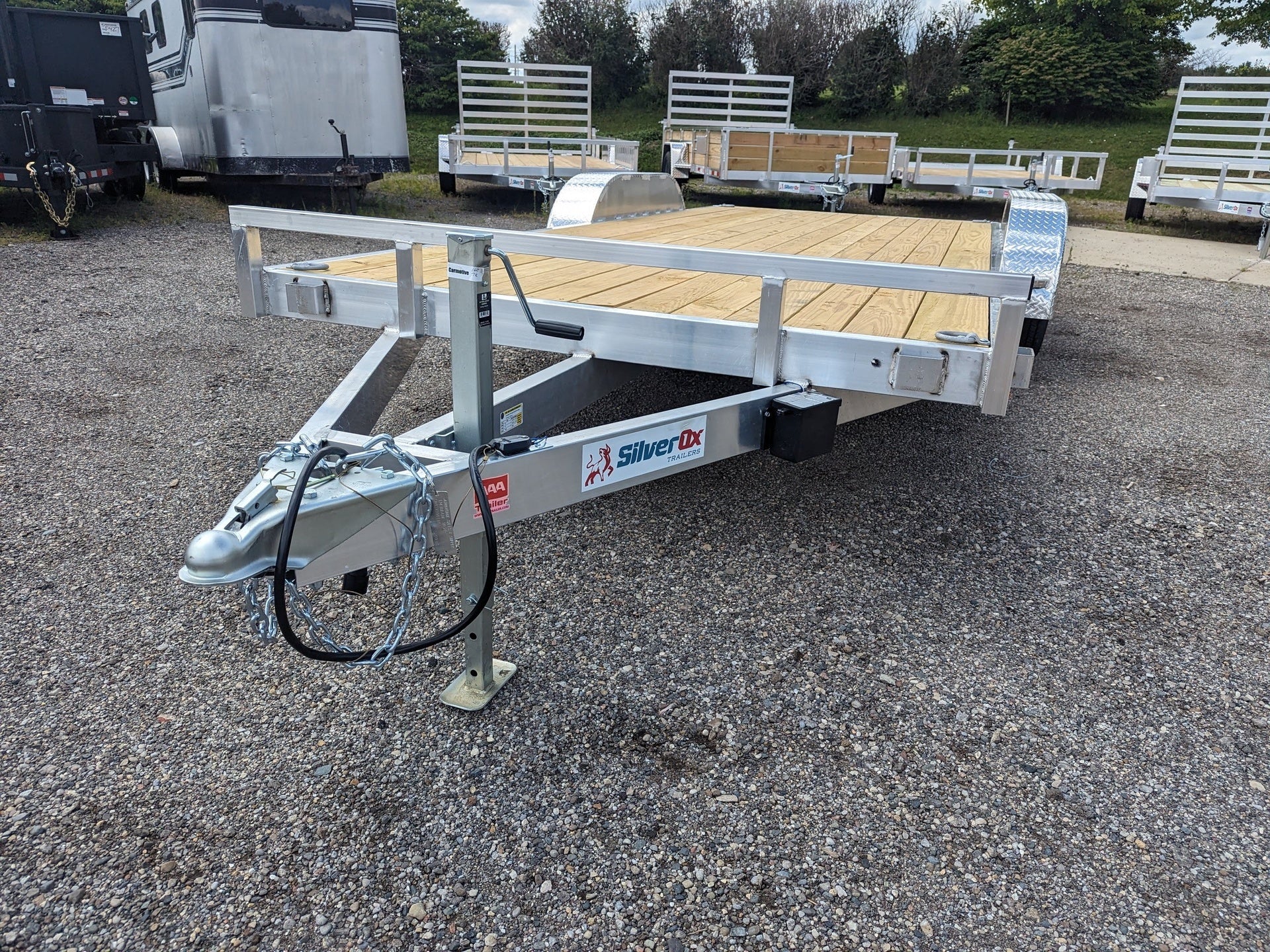 Silver trailer with a wooden platform on a gravel surface