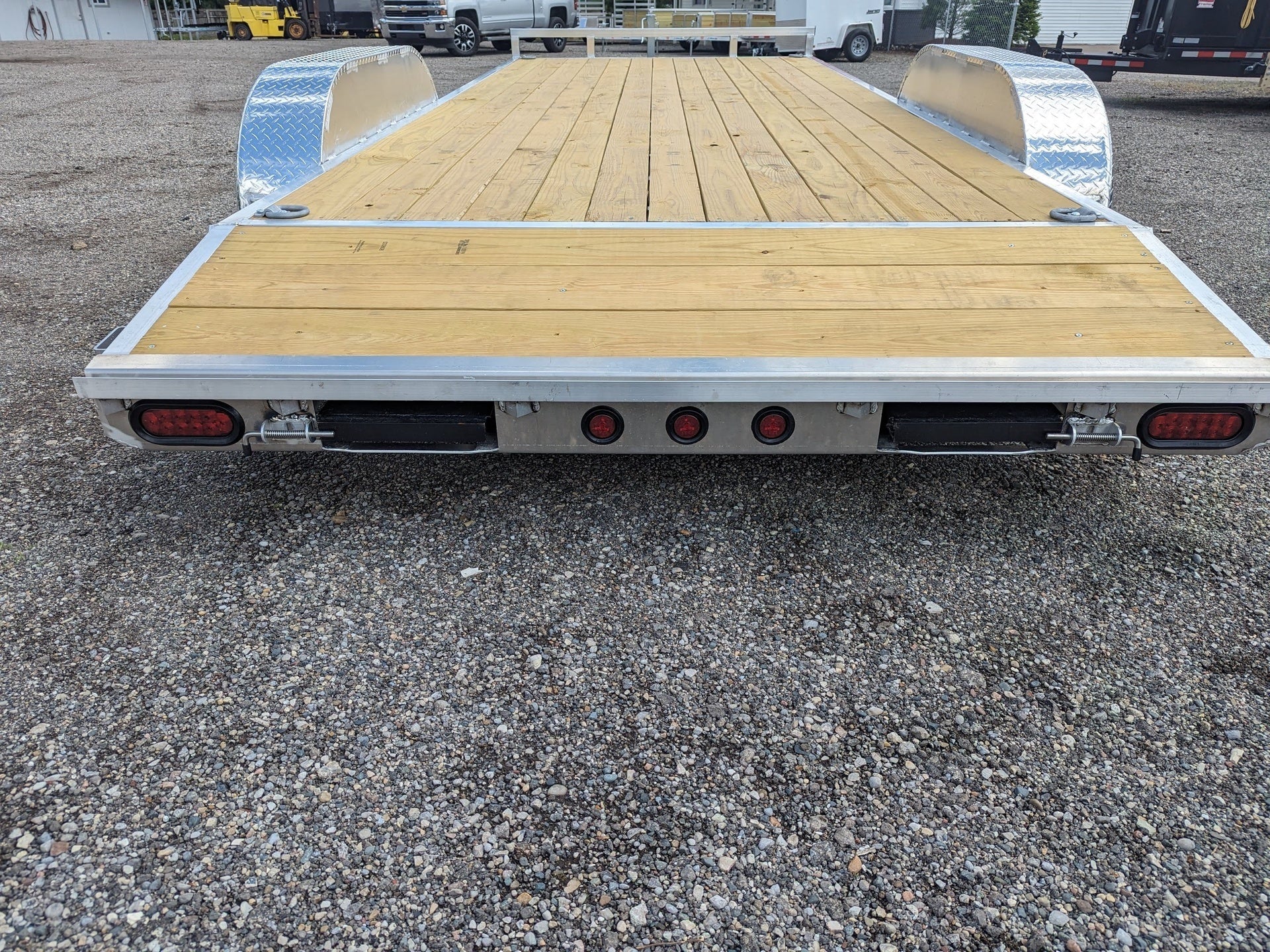 Car trailer with wooden deck on a gravel surface