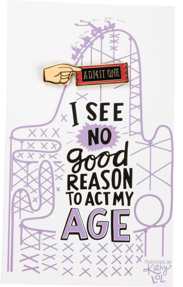 An enamel pin with 'Admit One' and a hand holding a ticket, above a card that reads 'I SEE NO GOOD REASON TO ACT MY AGE'.