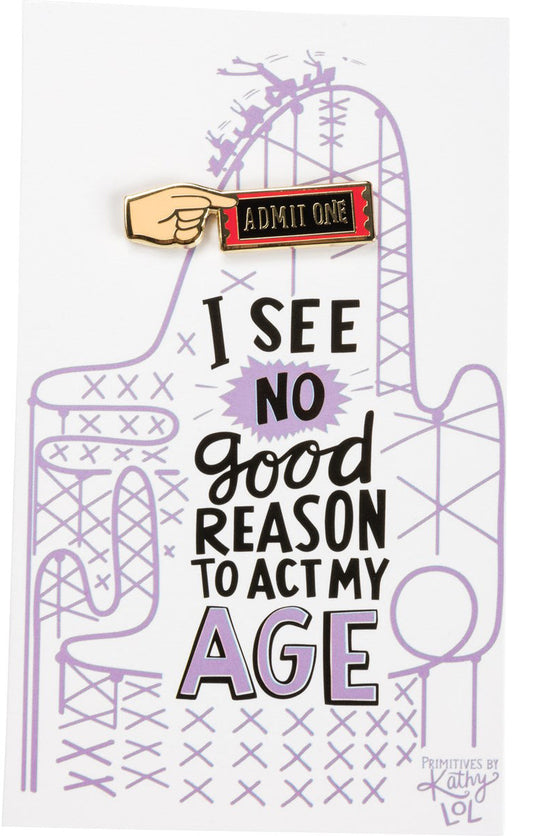 An enamel pin with 'Admit One' and a hand holding a ticket, above a card that reads 'I SEE NO GOOD REASON TO ACT MY AGE'.