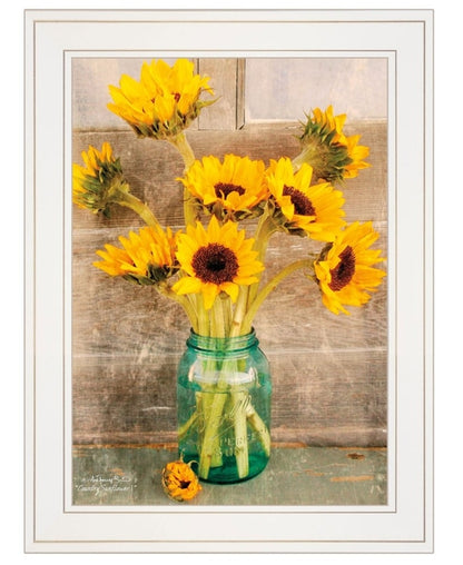 Framed artwork of sunflowers in a green jar against a wooden background