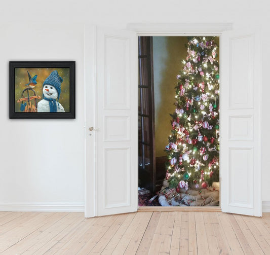 Decorative door with a Christmas tree and a framed picture of a snowman and bird on a white wall.