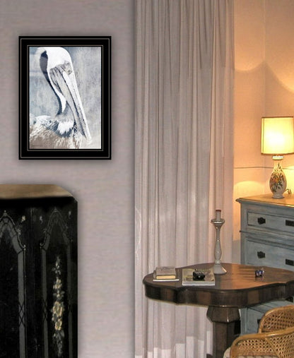 Framed artwork on a wall above a fireplace with a lamp and table in the background.
