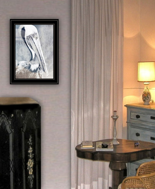 Framed artwork on a wall above a fireplace with a lamp and table in the background.