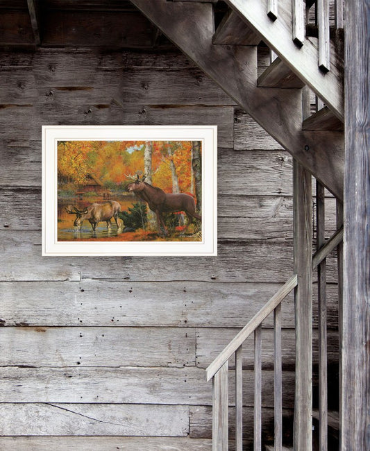 Framed painting of moose in a forest scene on a wooden wall next to a staircase.