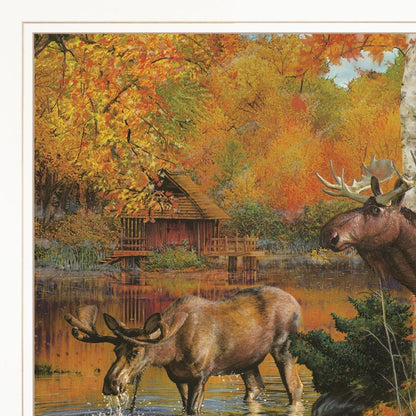 Two moose by a lake with a wooden cabin in the background during autumn.