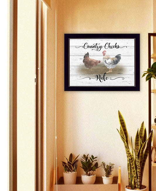 Framed artwork with chickens and text on a wall above a shelf with plants.