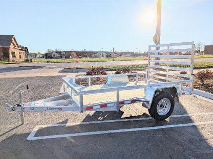 White utility trailer parked on a paved surface with a clear sky.