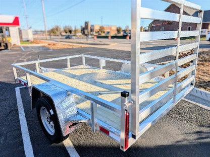 White utility trailer parked in a lot with buildings in the background