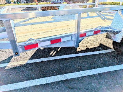 Metal trailer with a black mat on a paved surface
