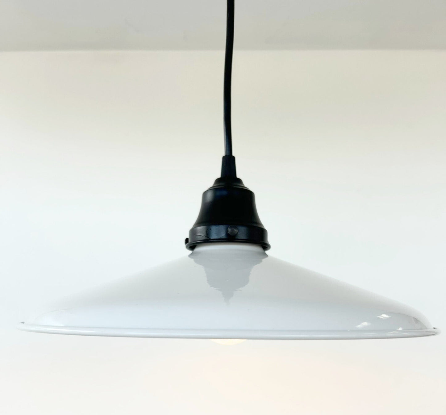 White pendant light with black fixture on a white background