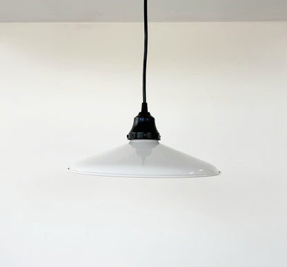 White pendant light with black cord on a white background