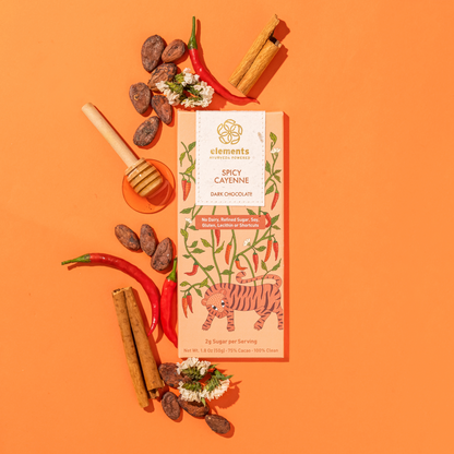 Spicy cayenne dark chocolate bar with ingredients on an orange background