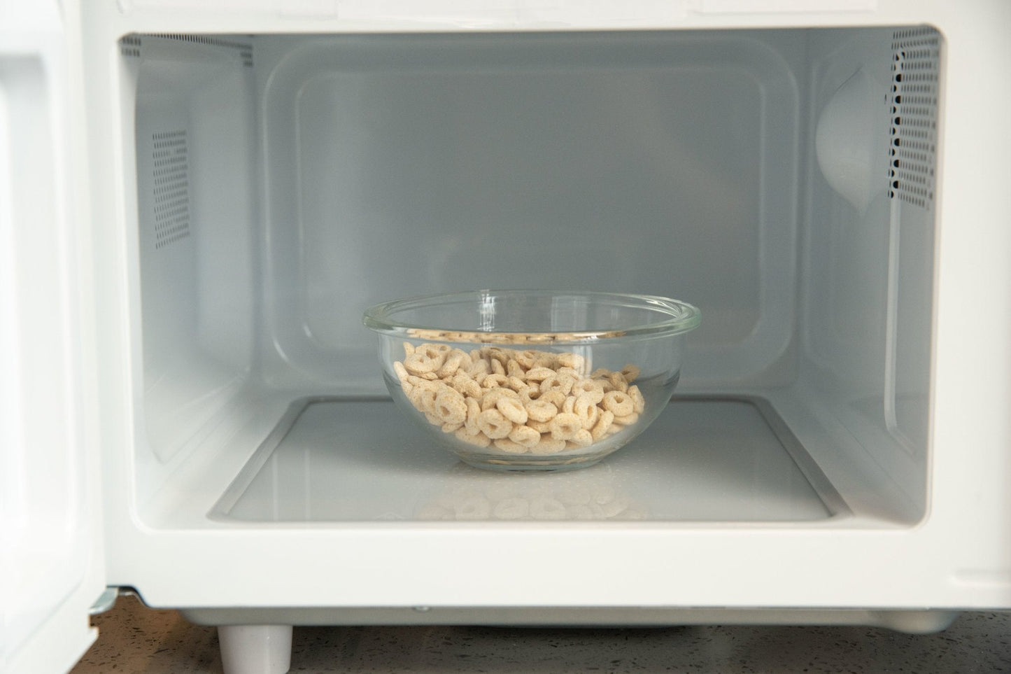 Glass bowl with cashews inside a microwave oven