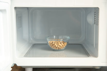 Clear bowl with chickpeas inside a microwave oven