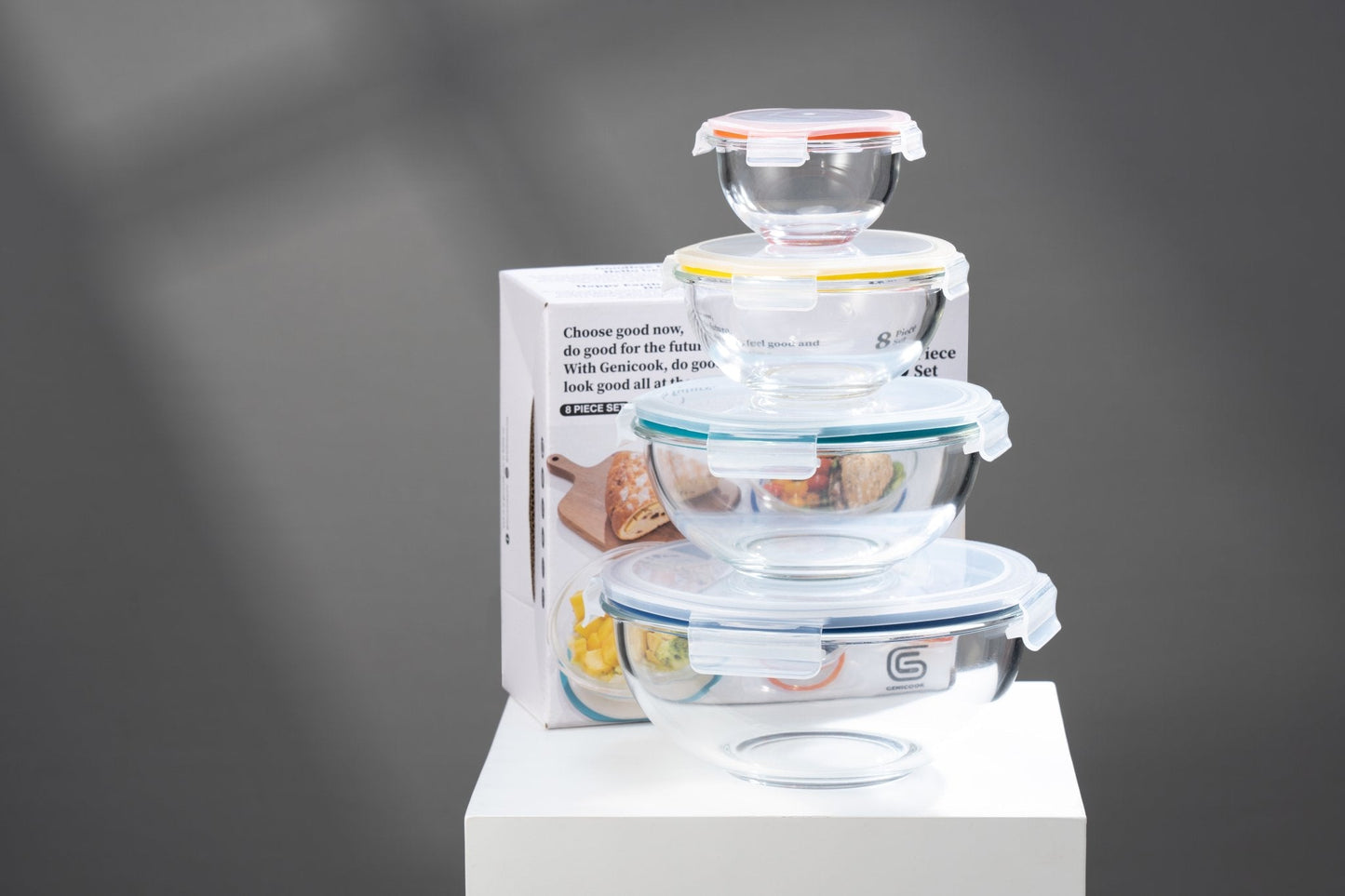 Set of glass food storage containers with lids on a gray background