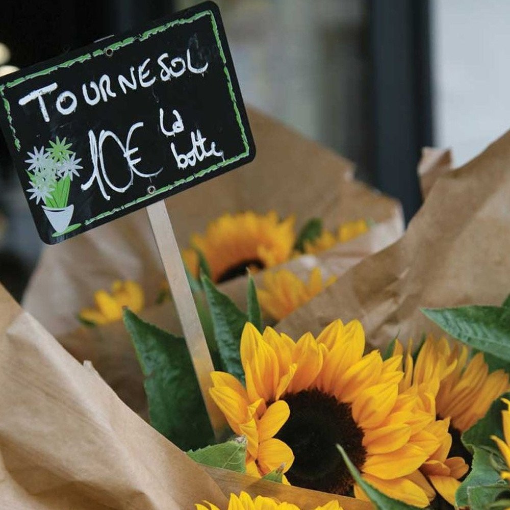 Sunflowers with a small blackboard sign in a market setting