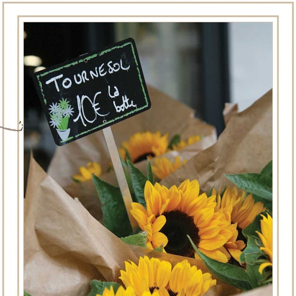 Bouquet of sunflowers with a price sign in French indicating '10€ la boite'.