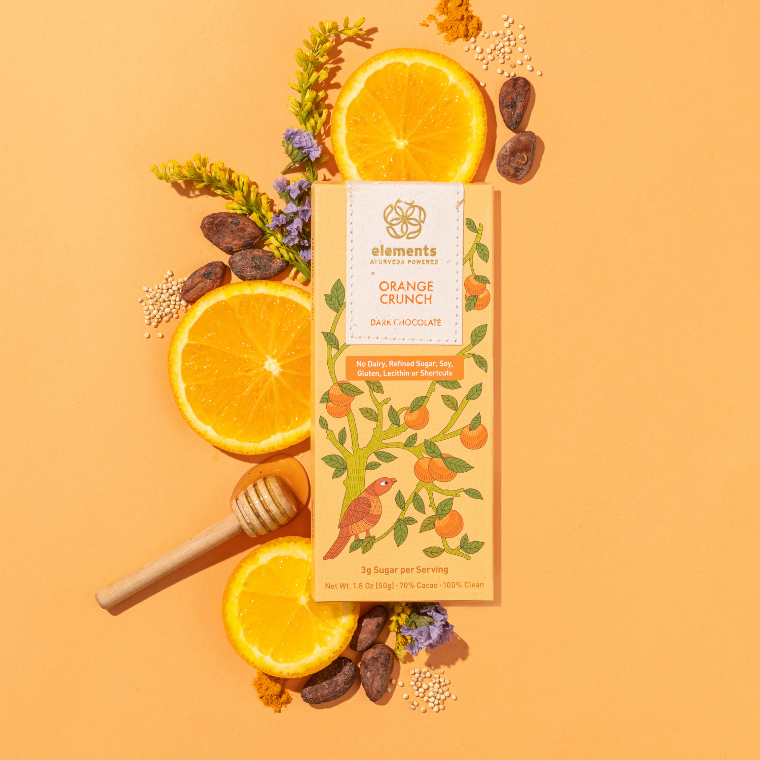 Box of 'Orange Crunch' dark chocolate with oranges, honey, and flowers on an orange background