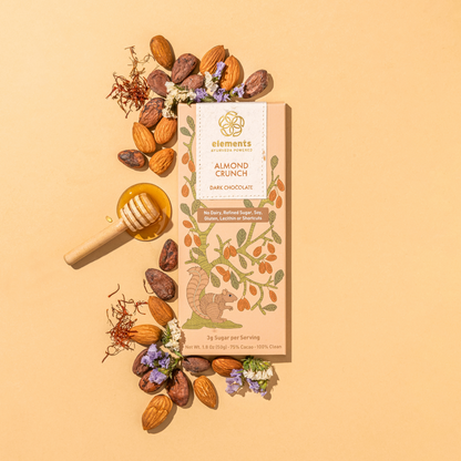 Almond Crunch dark chocolate bar with almonds, honey, and flowers on a beige background