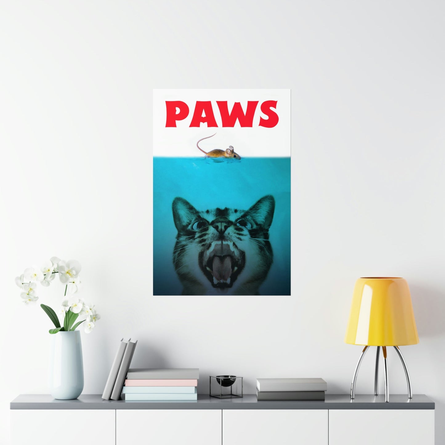 Poster with a cat underwater and 'PAWS' text on a wall above a shelf with decor items.