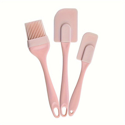 A set of three silicone kitchen utensils, including a spatula, a brush, and a scraper, in a light blue color, displayed on a two-tone background with orange and blue sections.